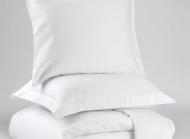 a stack of pillows and pillows on a bed