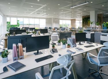 Modern open-plan office with computers, chairs, potted plants, and organized workstations