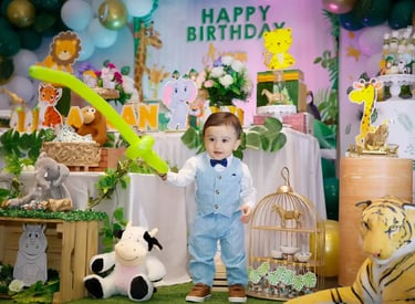 a young boy standing in front of a birthday party