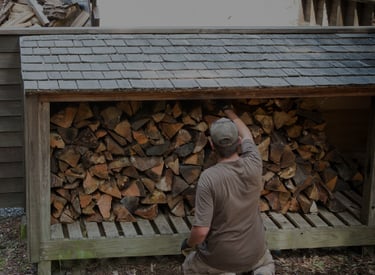 un homme travaille avec les bûches, en empilant les unes sur les autres