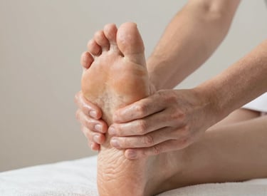 A bottle of mineral supplement labeled 'Magne-Granat' sits on a wooden cutting board. Beside it, a halved orange and sprigs of rosemary add a touch of natural freshness. The background features a light, textured wall.