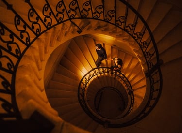 Foto artística de pareja en su sesión de pedida de mano subiendo escaleras elegantes tomados de la mano en Quito Ecuador boda
