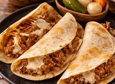 Quesadillas de barbacoa de res con queso fundido, salsa y limones en Querétaro.