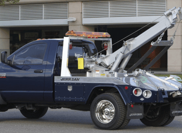 A blue tow truck with silver equipment
