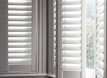 picture of a bay window with hardwood shutters