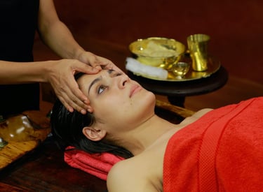 Woman receiving an Ayurvedic head massage in a serene setting, showcasing traditional healing practices of Kerala.