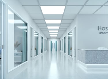 Pasillo de hospital con puertas de consultorios y sala de información, representando red hospitalari