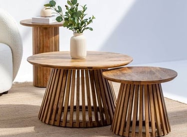 a set of tables with a plant in a room