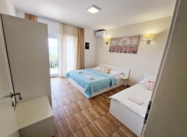 room with a two beds, cabinet and windows