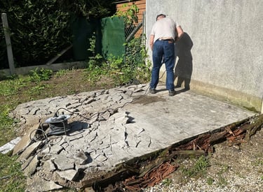 homme entrain de cassé du béton avec un marteau piqueur.