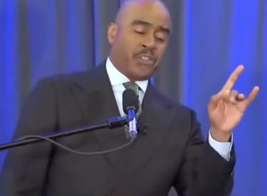 Gino Jennings of Truth of God Broadcast showing hand signs at the FCOOLJC on March 23 2024