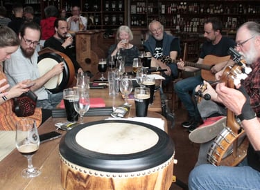 Musicians playing traditional folk music instruments during a lively session at an Irish pub.