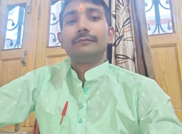 Portrait of a man wearing a light green kurta and a traditional tilak on his forehead.