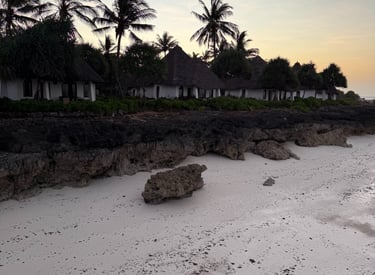 Relaxing beach escape in Zanzibar with lounge chairs and turquoise water planned by ThetravelingTrendie