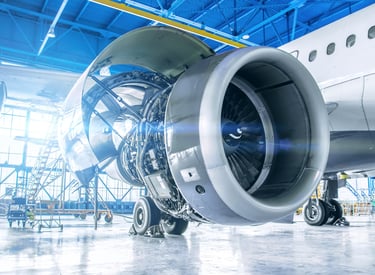 Commercial aircraft engineering during routine maintenance with cowlings open and engine showing. 