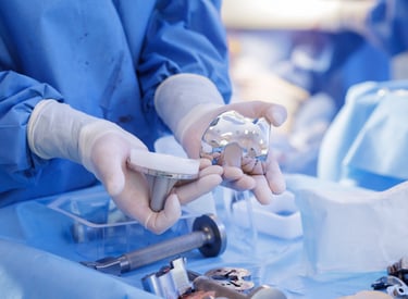 medical technical inspecting a set of orthopedic knee implants.