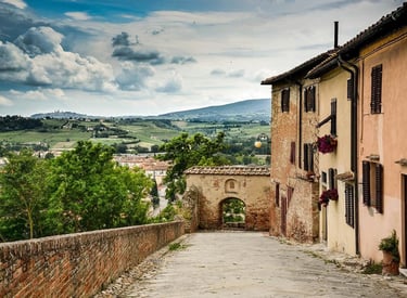 Cobblestone street in medieval Certaldo Alto, Tuscany, featuring historic architecture and panoramic valley views