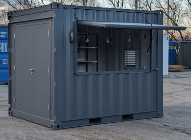 Custom grey shipping container kiosk with a large flip-up serving window for outdoor retail use.