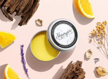 Natural solid shampoo bar in a tin surrounded by fresh orange slices, lavender, and wood.
