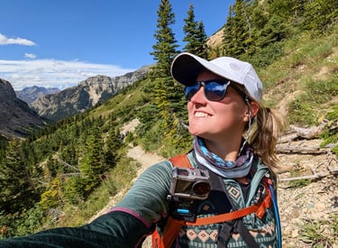 Hiker on the Crypt Lake Trail with mountain views in Waterton Lakes National Park.