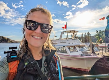 Woman smiling in front of the Miss Waterton shuttle boat before hiking Crypt Lake in Waterton Lakes
