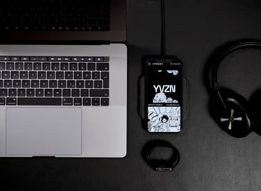 A laptop and iPhone on a table displaying the YVZN website