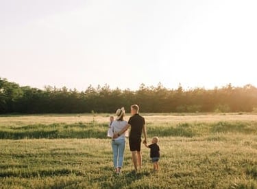 familia joven caminando en una pradera al atardecer