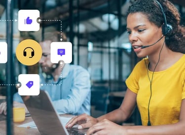 a woman in a yellow shirt is sitting at a table with a laptop and a