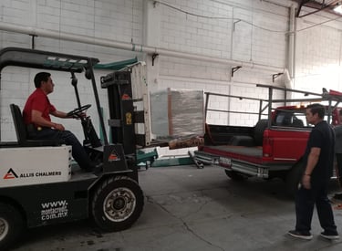 hombre en montacargas llevando transformador a camioneta rija