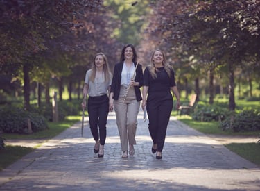 three women walking down a path in a park