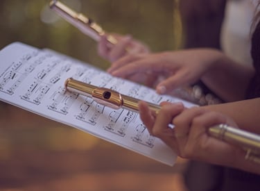 a person holding a flute and playing flute