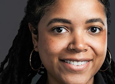 headshot of a woman with long hair and earrings on her head