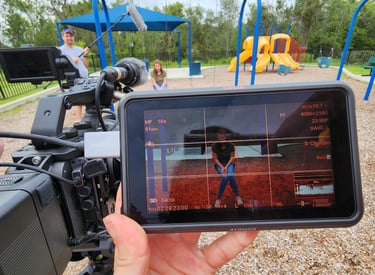 Hands-on filmmaking training using professional camera equipment during outdoor production workshop