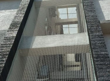 Installation team fitting pigeon nets on a commercial property in Bangalore.