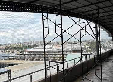 Installation team fitting pigeon nets around a commercial building.