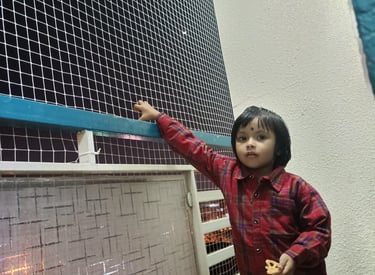 Close-up of a sturdy balcony safety net protecting a child playing on the balcony.