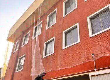 Close-up of durable netting material stretched across a building facade.