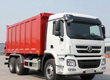 A bright red tipper truck unloading gravel on a road construction project.