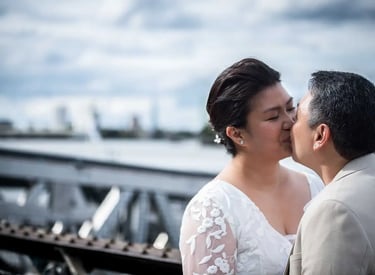 Two brides share a kiss during an outdoor wedding photo shoot in Greenwich