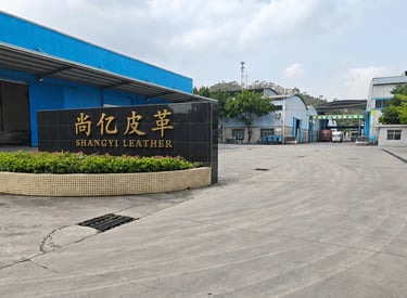Shangyi Leather manufacturing facility entrance with a modern black stone sign and industrial buildings.