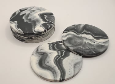 Handmade black and white marbled gypsum coasters in a stack.