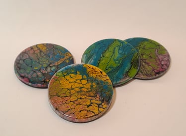 Set of four round handmade resin coasters featuring colorful fluid acrylic pour art designs.