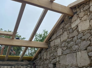 De nouvelles poutres en bois ont été installées sur un mur en pierre rustique pour un projet de réno