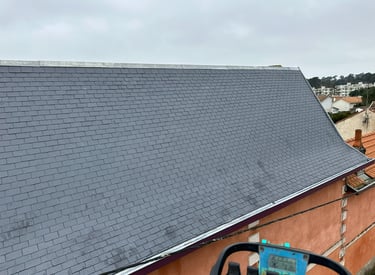 Installation professionnelle de toiture en ardoise sur un bâtiment résidentiel avec des bardeaux gri