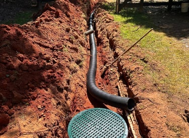 Exposed install of catch basin connected to 6 inch pipe routing water clear off property
