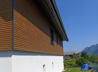 a house with a tent pitched in the grass