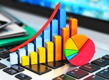 Business growth data visualization showing a 3D bar chart and pie graph on a laptop keyboard.