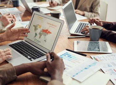 eam reviewing business analytics charts on laptops and printed reports