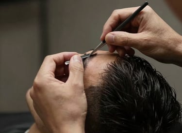 A stylish barber cutting a man's hair in a cozy home setting with modern decor.