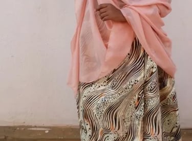 a woman in a black top and a pink scarf